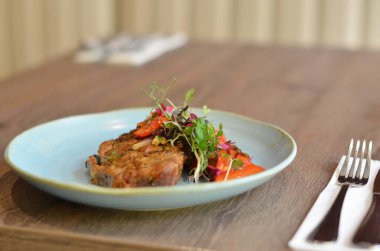 çatal ve bıçakla masada bir tabak yemek.