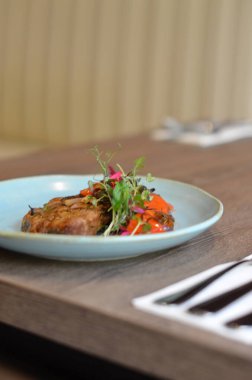 çatal ve bıçakla masada bir tabak yemek.