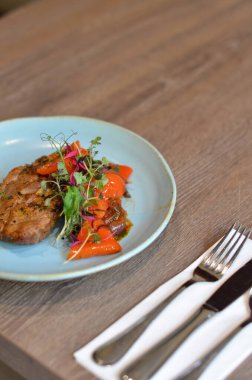 Çatal ve bıçakla bir tabak yemek.