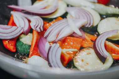 Bir kase soğanlı sebze salatası, kabak ve domates, yakın plan.