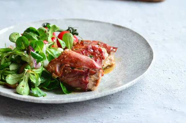 Kırsal bir tabakta servis edilen yemeğin güzel arka planı, İtalyan mutfağı, ızgara dana eti parma jambon ve adaçayı, karışık salata, yakın görüş.,