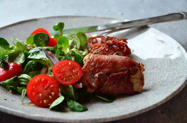 Kırsal bir tabakta servis edilen yemeğin güzel arka planı, İtalyan mutfağı, ızgara dana eti parma jambon ve adaçayı, karışık salata, yakın görüş.,