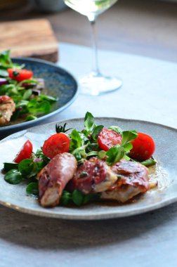 Kırsal bir tabakta servis edilen yemeğin güzel arka planı, İtalyan mutfağı, ızgara dana eti parma jambon ve adaçayı, karışık salata, yakın görüş.,