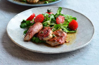 Kırsal bir tabakta servis edilen yemeğin güzel arka planı, İtalyan mutfağı, dana eti saltimbocka, karışık salata, yakın görüş.,
