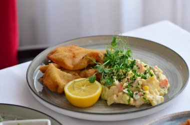 Bir tabak kızarmış balık ve salata.