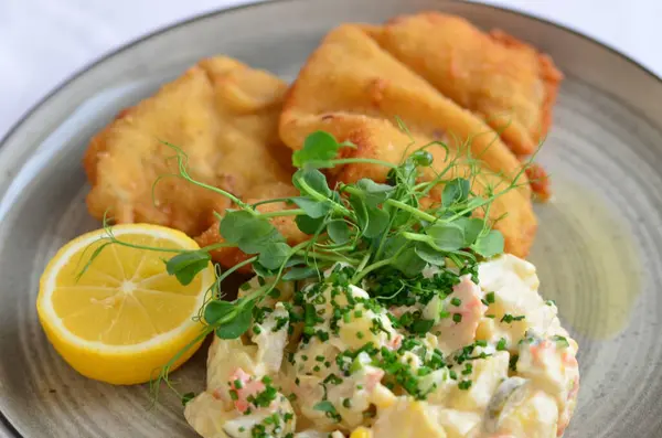 fish with chips and fried fish on a plate with lemon. high quality photo