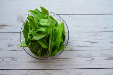 Tahta masadaki beyaz tabakta taze yeşil salata.