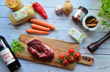 Ahşap bir arka planda baharatlı ve otlu çiğ et.