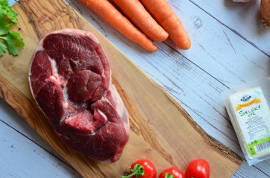 Ahşap arka planda sebzeli ve baharatlı çiğ et.