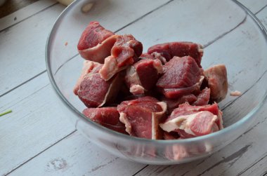 Baharatlı ve bıçaklı beyaz tabakta çiğ tavuk eti.