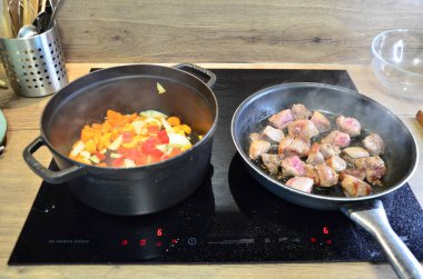 Tahta arka planda tavada et ve sebzeli pilav.