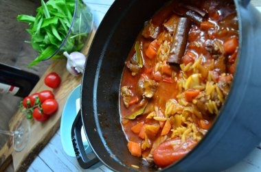 Tahta arka planda tavada et ve sebzeli pilav.