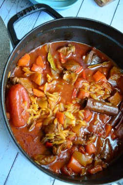 Tahta arka planda tavada et ve sebzeli pilav.