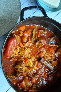 Tahta arka planda tavada et ve sebzeli pilav.