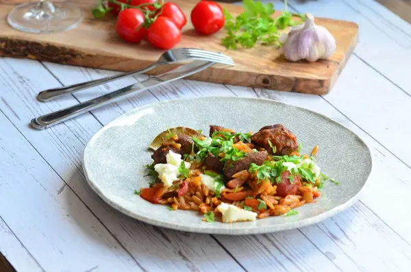 Domates ve orzo ile pişirilmiş kuzu eti. Geleneksel Yunan yemekleri.