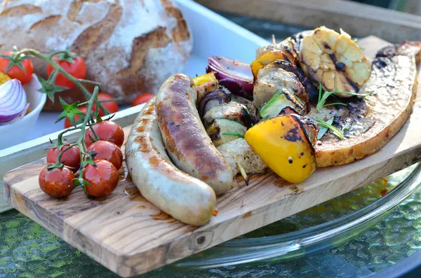 background of food prepared on outdoor grill with open fire, sausages, vegetables, steak, different color variation