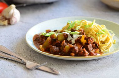 Ahşap bir masada kızarmış tavada Stroganoff bifteği.