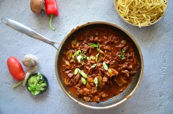  Aile yemeği geçmişi, servis edilen yemekler, sığır eti, spaetzle, mavi tabak, üst manzara.