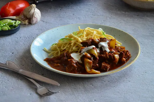 Ahşap bir masada kızarmış tavada Stroganoff bifteği.