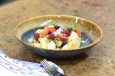 Geleneksel Çek tatlısıyla mavi tabak, haşhaş tohumlu patates gnocchi ve süzme peynir, servis edilen yemeğin arka planı, meyve süslemesi.