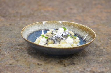 Geleneksel Çek tatlısıyla mavi tabak, haşhaş tohumlu patates gnocchi ve süzme peynir, servis edilen yemeğin arka planı, meyve süslemesi.