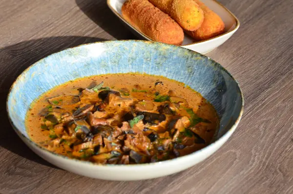 Mantar kebabı, vejetaryen gulaş ve ahşap arka planda otlar.