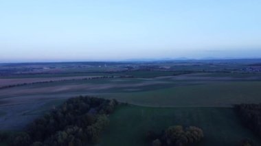 Baharda bir tarlaların ve ormanların üzerinde gün batımında hava manzarası