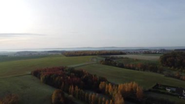 Ağaçlarla kaplı küçük bir köyün ve bulutlu bir sonbahar gününün hava görüntüleri.