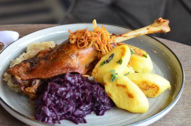 Kızarmış kaz budu, kırmızı lahana ve mantı.