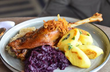 Kızarmış kaz budu, kırmızı lahana ve mantı.