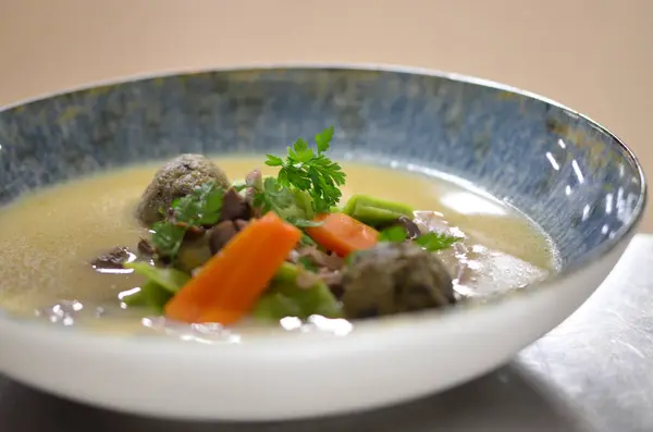 Geleneksel Çek yemeklerini yakından görmek, Kaldoun kaz çorbası, bir restoranda bir tabakta yemek servis etmek, ahşap masa, Saint Martin 'in kazları, geleneksel Çek bayramı yemekleri