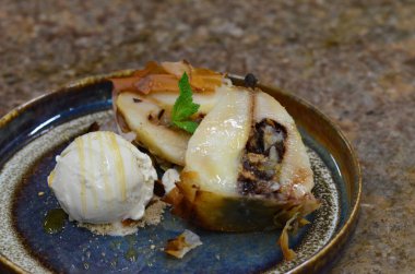 Hamur içinde fırında armut, dondurma, tabakta tatlı.