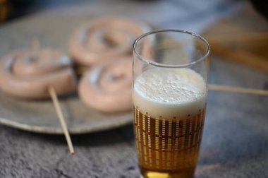 Bira ve sosis masada.