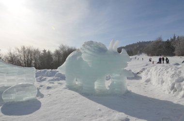 Kış manzarasının arka planında bir kardan adam heykeli