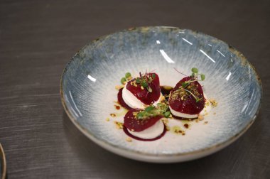 Krem peynirli pancar salatası ve beyaz tabakta otlar.