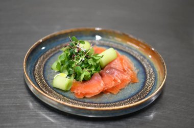 Siyah tabakta salatalı somon balığı yakından görülüyor.