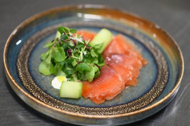 Siyah tabakta avokadolu somon balığı.