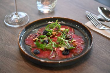 Bir dilim limonlu taze et salatası, bir dilim kırmızı biber, bir dilim kırmızı şarap, bir dilim roka...