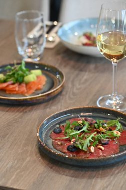 Tahta bir masada çeşitli aperatiflerin dikey görüntüsü.
