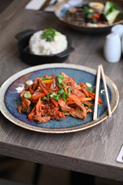 Kore yemeği, sebzeli baharatlı biftek salatası, kızarmış pirinç, sebze, sebze, baharat ve sebzeler siyah tabakta..