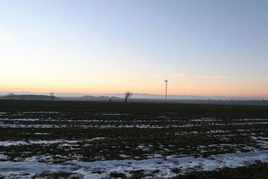 Ağaçlar ve yel değirmeni olan güzel bir manzara.