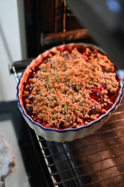 Lezzetli ev yapımı meyveli çörekler, canlı kırmızı böğürtlenler, sıcak, altın ve çıtır bir tatlıya dönüşmeye hazır.