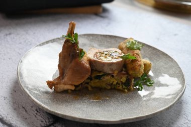 Geleneksel bahar tavşanı filetosunun içine kokulu bitkiler doldurulmuş. Yumuşak et, lezzetli dolguyu ortaya çıkarmak için dilimlenir. Kırsal ama zarif sunumu vurgular..