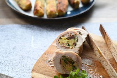 Geleneksel bahar tavşanı filetosunun içine kokulu bitkiler doldurulmuş. Yumuşak et, lezzetli dolguyu ortaya çıkarmak için dilimlenir. Kırsal ama zarif sunumu vurgular..