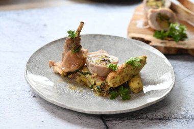 Geleneksel bahar tavşanı filetosunun içine kokulu bitkiler doldurulmuş. Yumuşak et, lezzetli dolguyu ortaya çıkarmak için dilimlenir. Kırsal ama zarif sunumu vurgular..