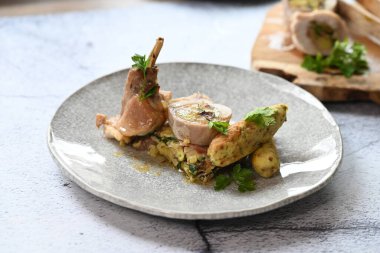 Geleneksel bahar tavşanı filetosunun içine kokulu bitkiler doldurulmuş. Yumuşak et, lezzetli dolguyu ortaya çıkarmak için dilimlenir. Kırsal ama zarif sunumu vurgular..