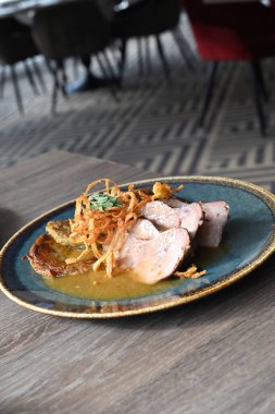 Kızarmış patatesli gözlemelerin yanında servis edilen, bol soslu leziz bir domuz boynu yemeği..