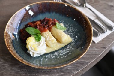 Bramborov iky olarak bilinen patates köftelerinin yer aldığı geleneksel bir Çek tatlı yemeği kremalı kuark peyniri ve olgun eriklerle servis edilir..