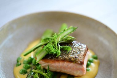 Tabakta kuşkonmaz soslu somon balığı.