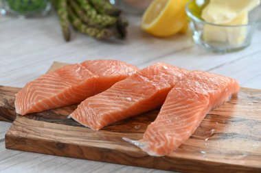 Yüksek kaliteli çiğ somon filetosu. Canlı turuncu bir tonu var. Açık arkaplanda güzelce yerleştirilmiş.